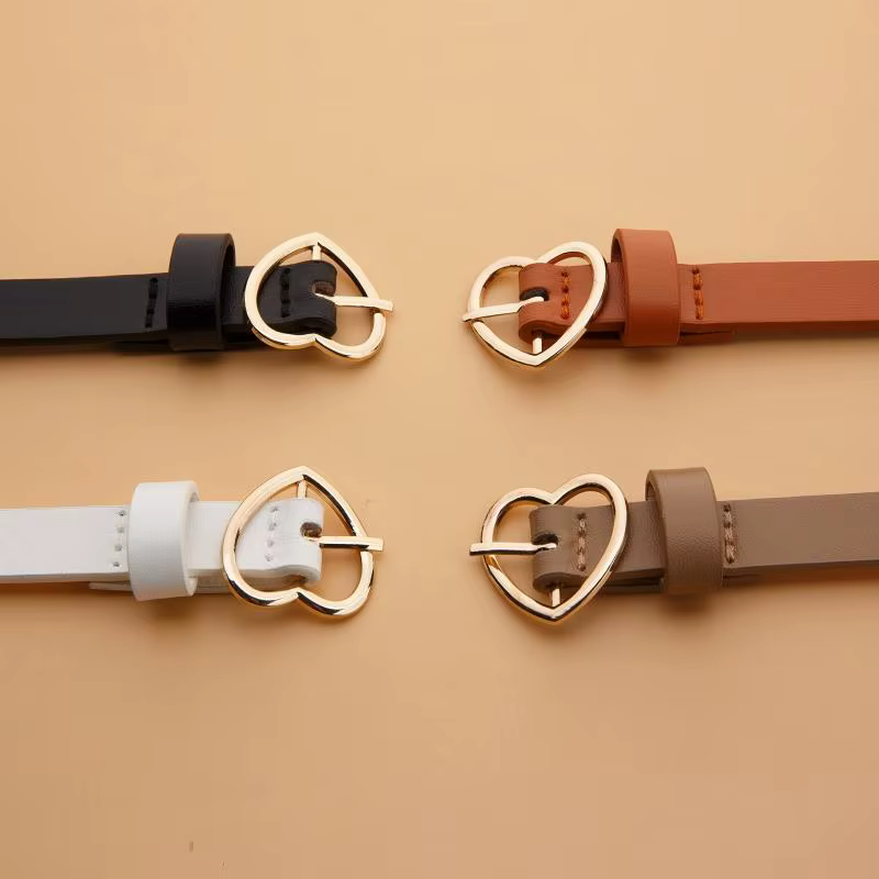 Un ensemble de trois ceintures fines à boucle dorée en forme de cœur