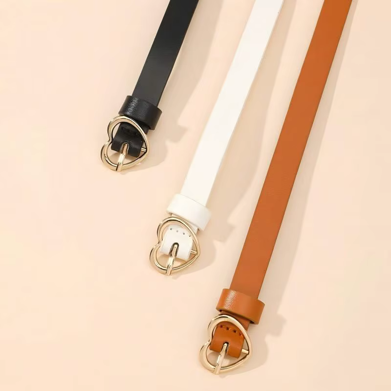 Un ensemble de trois ceintures fines à boucle dorée en forme de cœur